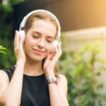 women-wearing-headphones-learning-English-songs
